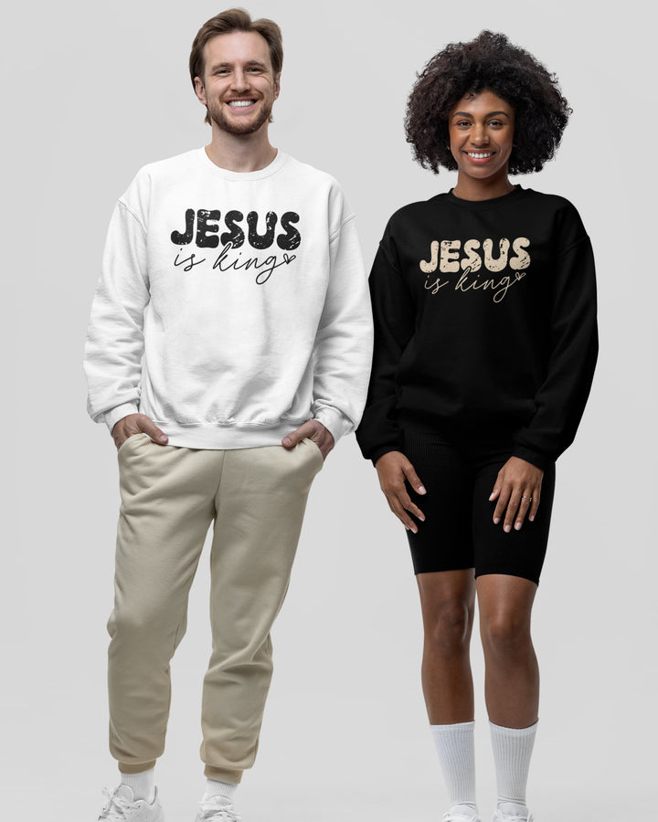 Man and woman wearing Jesus Is King Christian sweatshirts in white and black, standing side by side.