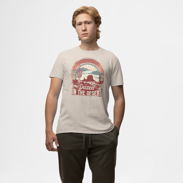 Man wearing a beige Western T-shirt with “Dazed in the Desert” cactus sunset graphic.