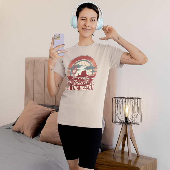 Woman wearing a beige Western T-shirt with “Dazed in the Desert” cactus sunset graphic.